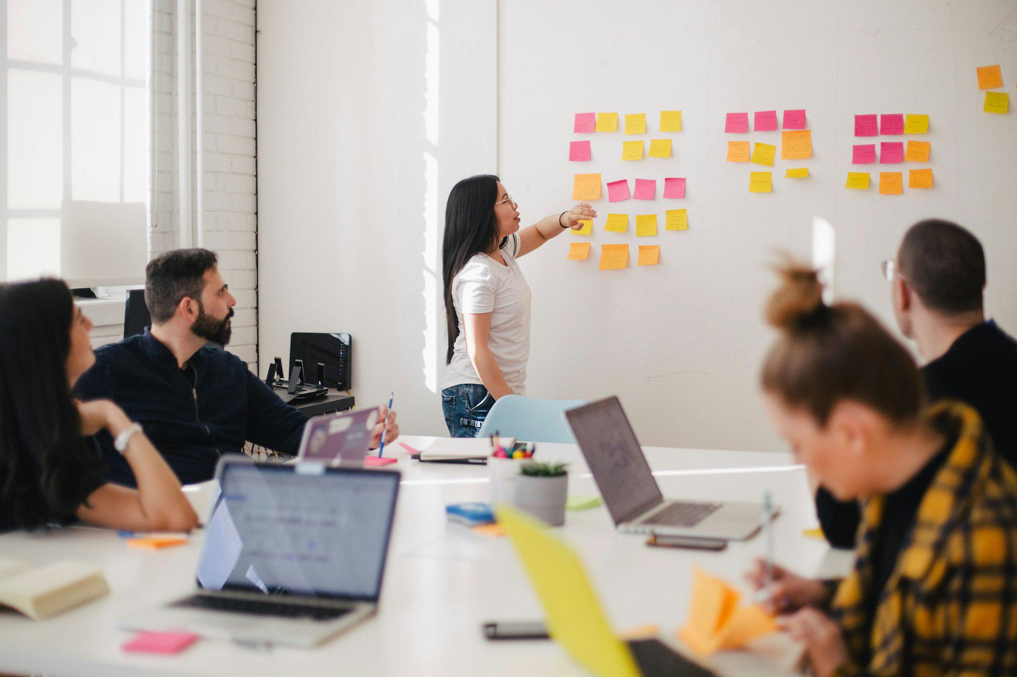 A team collaborating around sticky notes and laptops in a bright office