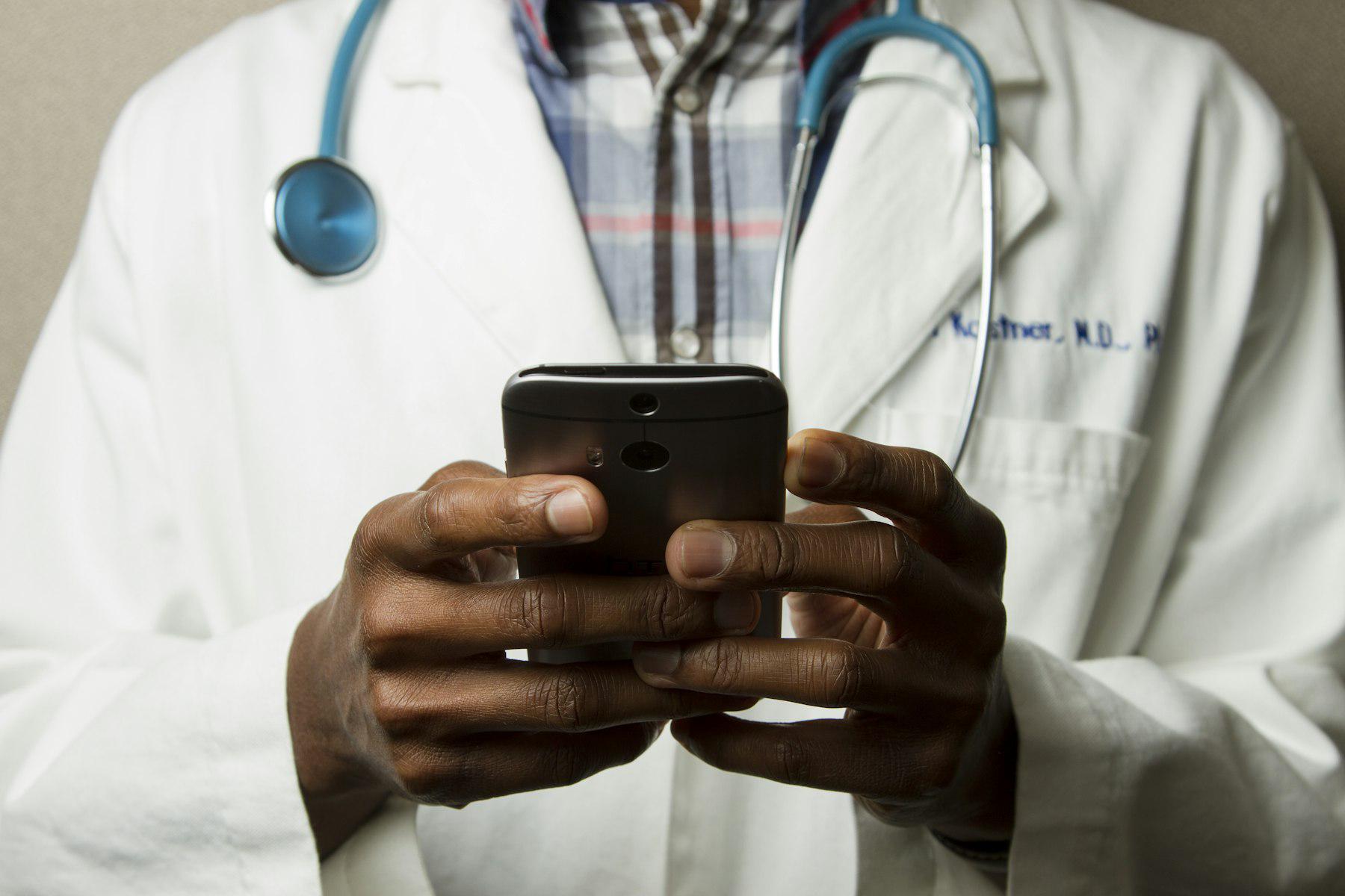 Doctor with a stethoscope using a smartphone