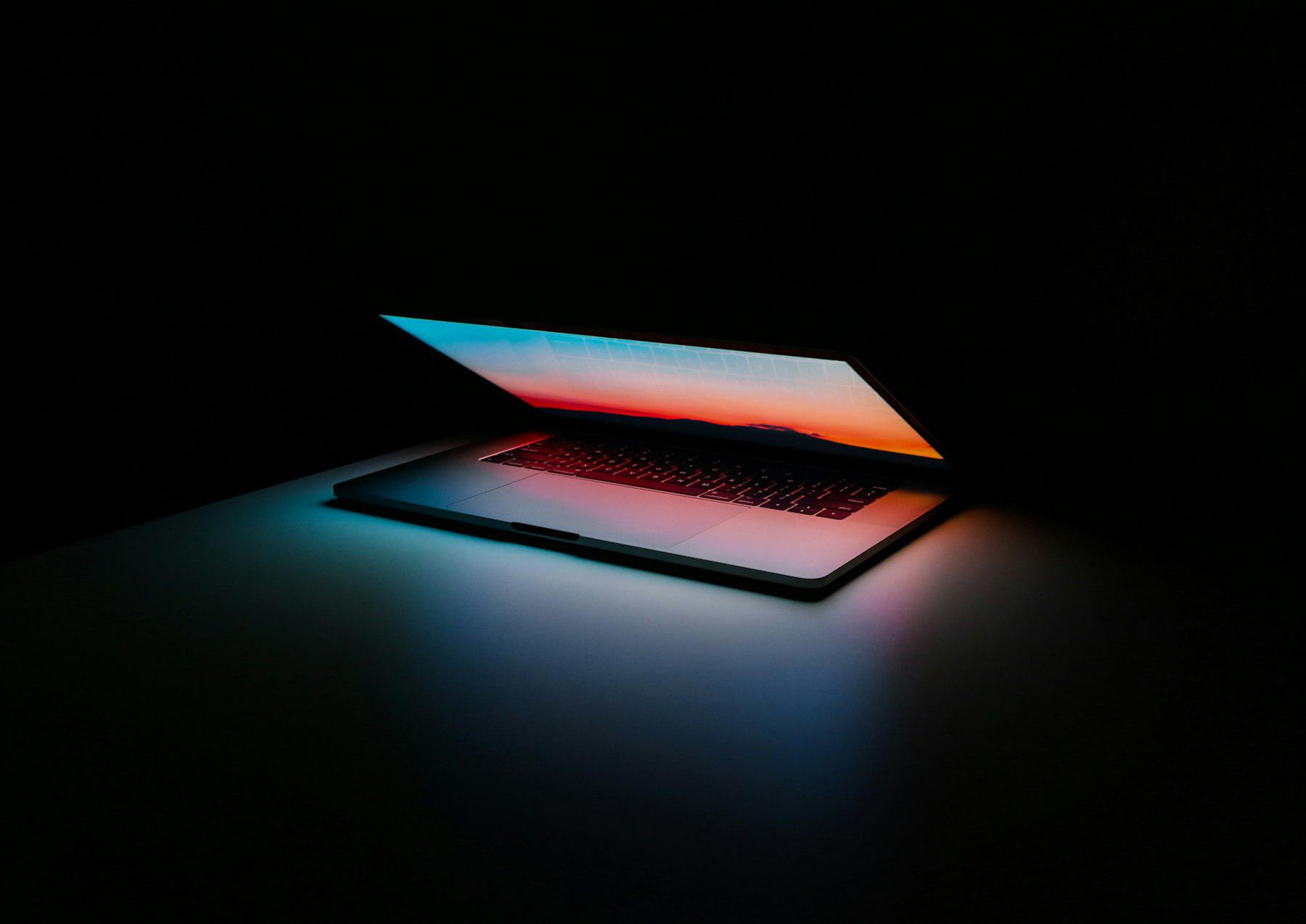 Laptop screen glowing in a dark room