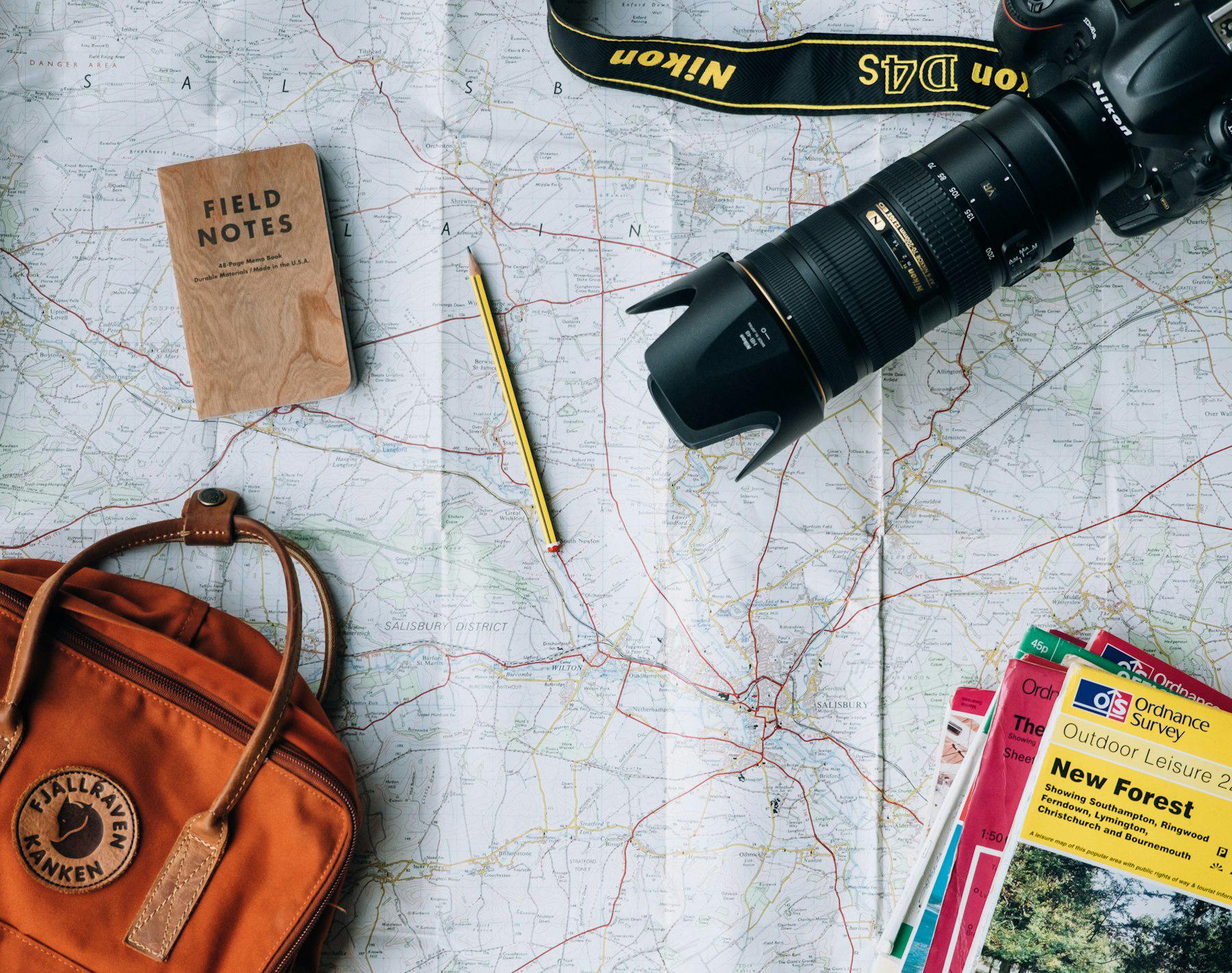 Map with a camera, notebook, and travel guides
